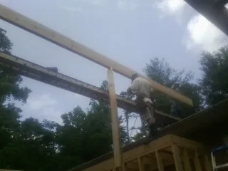Carpenter setting a ridge beam over a new addition frame — Ice Dam Removal by Roofing Brothers in Moorland