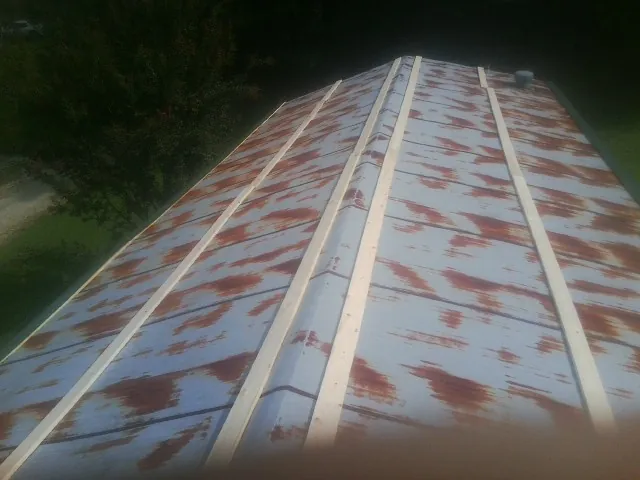 Rusted metal roof panels with new wood purlins before replacement — Storm Damage Roof Repair in Moorland by Roofing Brothers