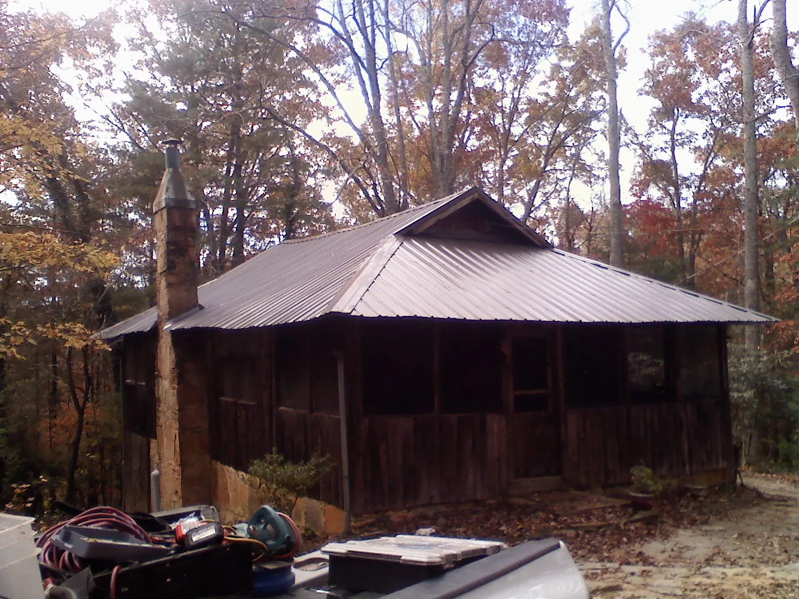 Brown metal hip roof on an old cabin with a stone chimney in Moorland